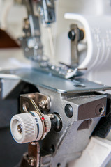 Fototapeta na wymiar Sewing machine with fabric industrial overlock mechanism