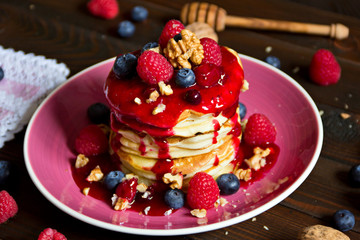 Pfannkuchen aufeinander gestapelt mit roter Grütze, Himbeeren,