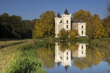 Fototapeta na wymiar Beverweerd castle in autumn colors reflecting in the Kromme Rijn river 