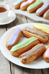 Eclairs with glaze on a grey wooden table