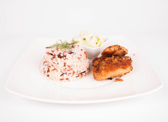 Pork chop (covered in breadcrumbs), three color rice and cucumber salad decorated with dill on a plate on white background
