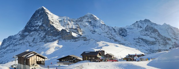 Naklejka premium High mountains Eiger, Monch, Jungfrau, and Sphinx-Observatorium over railway station Kleine Scheidegg. Jungfrau region, Switzerland.