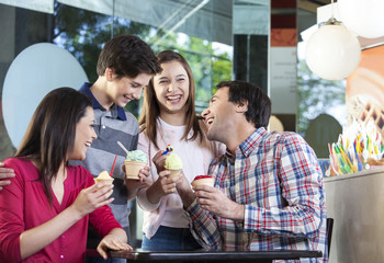 Family Laughing While Having Ice Creams In Parlor