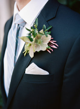 Groom wearing suit with buttonhole flowers
