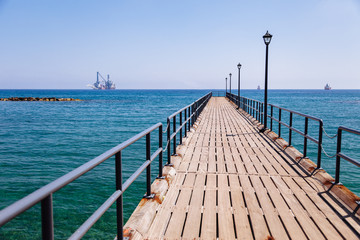 Fototapeta premium Linia brzegowa i promenada w Limassol, wyspa Cypr, Europa, Morze Śródziemne. Jasny, słoneczny dzień, błękitna woda i niebo.
