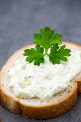 Bread with fresh cream cheese and red caviar on table.