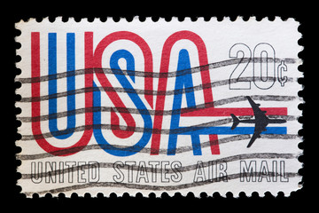 United States used postage stamp showing airplane flying USA word