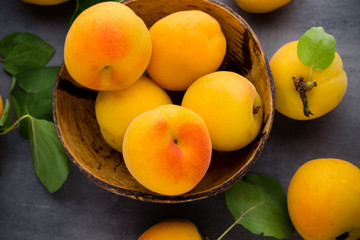 Apricots with leaves on the old wooden table.
