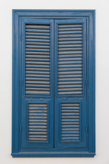 Closed blue window on light wall
