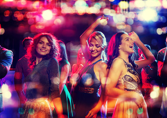 happy friends dancing in club with holidays lights - obrazy, fototapety, plakaty