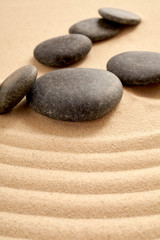 Fototapeta na wymiar Small group of smooth black stones in sand