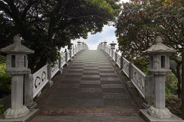 Fototapeta na wymiar Seonimgyo Bridge near Cheonjeyeon Falls on Jeju Island in South Korea viewed from the front.