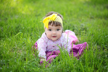 Cute baby girl on green grass