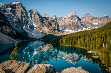Reflection of forest and snow capped mountains in lake
