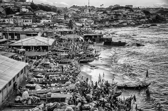 Fishing boats on coast by village, cape coast, ghana, black and white image