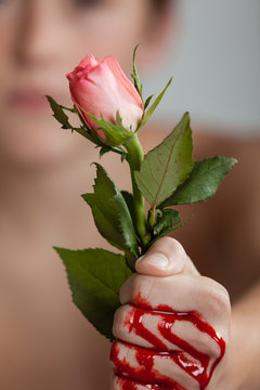 Boy Clutching Pink Rose in Blood Covered Fist