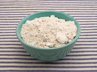 Caramel cake mix in a bowl on a blue striped tablecloth