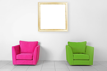 Living room interior with armchairs and picture frame on white wall background
