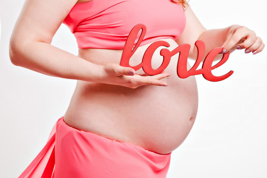 belly of a pregnant woman with the word love