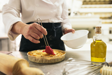 Obraz na płótnie Canvas Female pastry chef decorating dessert in the kitchen.