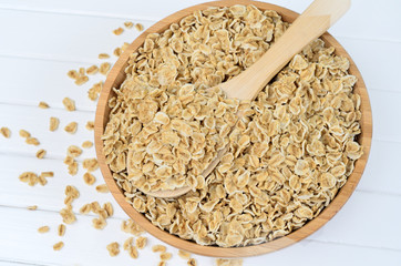 Oats in bamboo bowl and wooden spoon