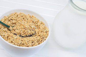 Oats in white bowl and pitcher with milk