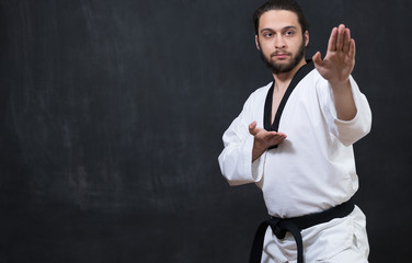 Karate Fighter in white Kimono Isolated on Black with Copy space