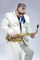 Naklejka premium Music Concept and Ideas. Handsome Caucasian Musician with Saxophone Against White