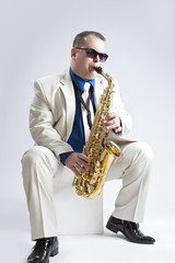 Naklejka premium Music Ideas and Concepts. Handsome and Caucasian Music Player Posing with Alto Saxophone Against White