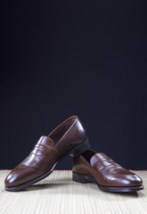 Shoes concepts. Men's Brown Stylish Penny Loafer Shoes On Straw Surface