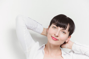 Fototapeta premium Beautiful young model woman in white shirt posing over white ba