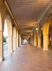 The arched stone colonnade with suspended lanterns