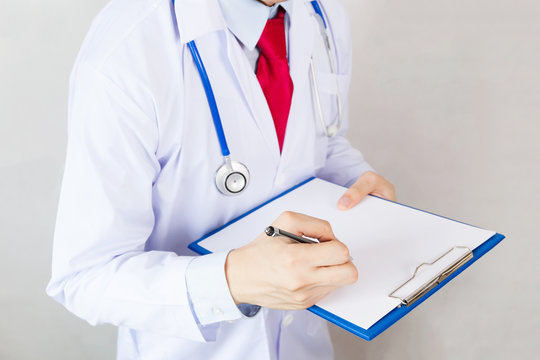 Medical doctor writing prescription on white isolated background (Focus on clipboard)