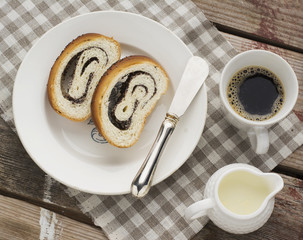close up of sliced poppy seed roll on white plate