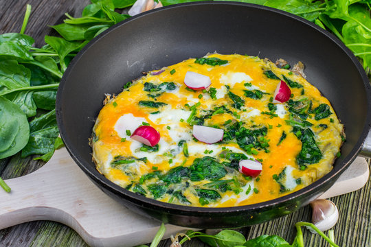 Spinach Omelette with Radish in the Pan on Wooden Board