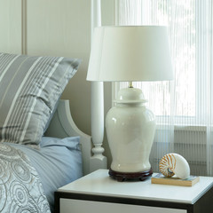 cozy bedroom interior with pillows and reading lamp on bedside table