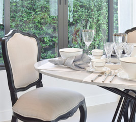 dining table and comfortable chairs in modern home with elegant table setting