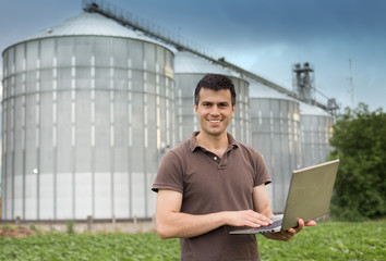 Farmer in front of grain silo