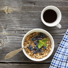 Breakfast table with granola, coffee and fresh berries