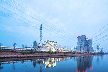 modern factory near river in blue sky at dawn