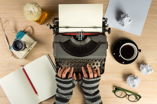 vintage typewriter with work stuff and hands overhead