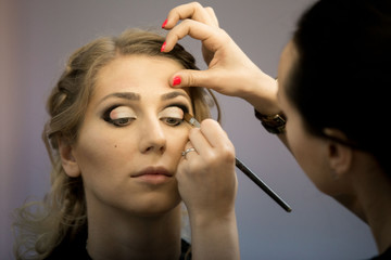 Fototapeta premium Application of wedding makeup. Preparation of the bride. Boho style. Ease of braided hair braids.