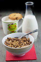 Healthy cereal with milk and cookie on wood table