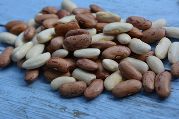 разноцветная  фасоль на голубом деревянном фоне