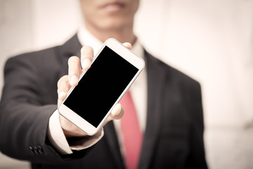 Businessman holding smart phone,cellphone,phone in vintage color