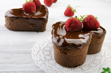 Heart cake. Pieces of chocolate cake with fresh strawberry on wooden background.