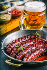 Sausage. Roasted chorizo sausage. Roasted spicy sausage chorizo home hotel or restaurant with beer vine brandy cognac whiskey. Still life. Toned photo.