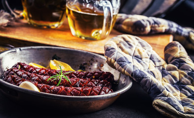 Sausage. Roasted chorizo sausage. Roasted spicy sausage chorizo home hotel or restaurant with beer vine brandy cognac whiskey. Still life. Toned photo.