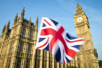 Fototapeta na wymiar Great British Union Jack flag flying in motion blur in front of Big Ben and the Houses of Parliament at Westminster Palace, London, in preparation for the Brexit EU referendum
