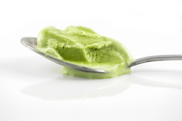 Melted green tea ice cream on teaspoon